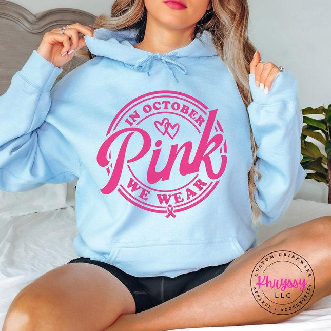Light Blue hoodie in pink ink styled flat with the We Wear Pink badge design