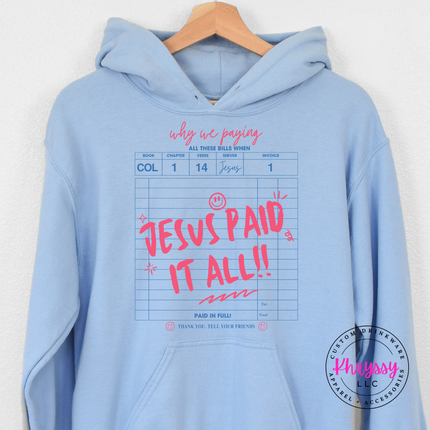 Light blue hoodie showing a bold faith receipt and paid-in-full script.
