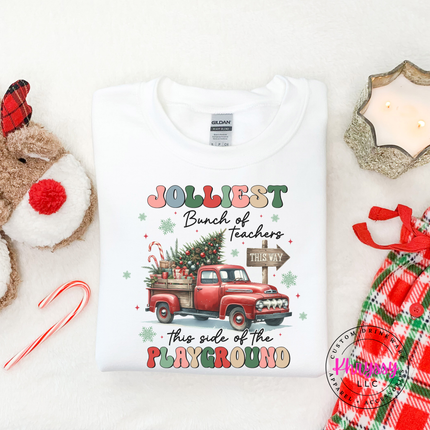 Flat lay of the Jolliest Teachers truck Christmas crewneck sweatshirt in White.