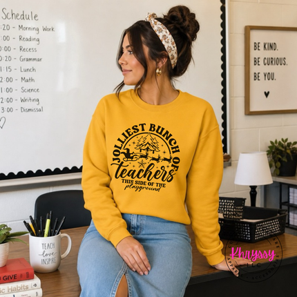 Model wearing the Jolliest Teachers crewneck sweatshirt in Gold.