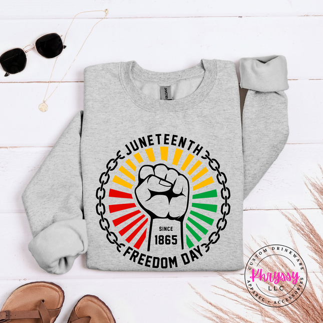 Ash crewneck sweatshirt with a black Juneteenth raised-fist Freedom Day graphic.