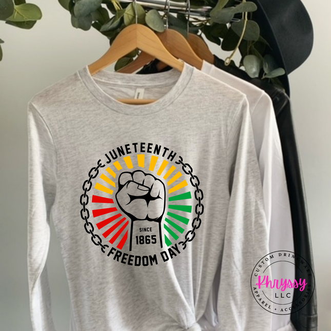 Ash long sleeve tee with a black Juneteenth raised-fist Freedom Day graphic.
