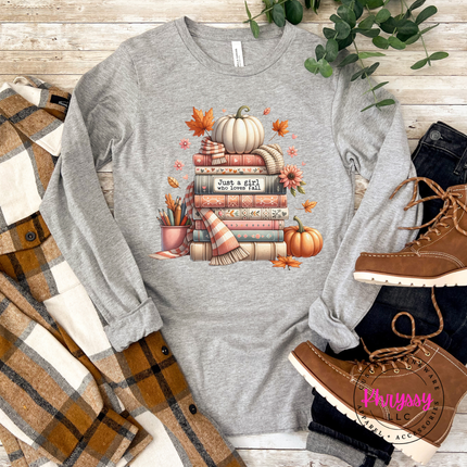 Woman wearing an Athletic Heather tee with a cozy book stack design.
