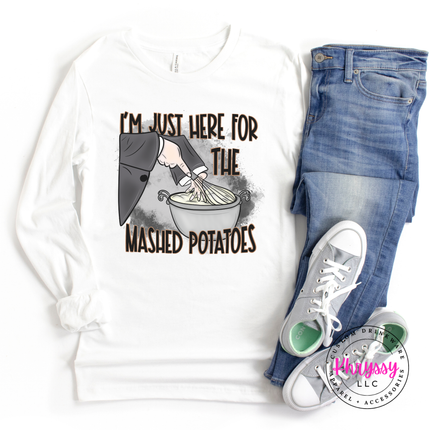 White tee featuring a witch's sleeve mixing potatoes.