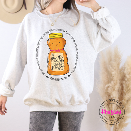 Person wearing a ash sweatshirt with a honey jar graphic and text, standing against a neutral background.