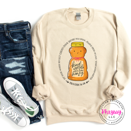 Sand sweatshirt with honey bear design and text, paired with jeans and sneakers on a white background.