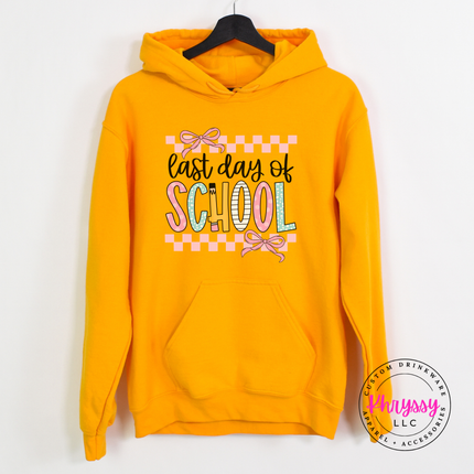 Gold pullover hoodie showing pastel pinks and bows on a school design.