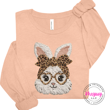 Pink long sleeve shirt with a bunny design wearing glasses and a leopard print bow on a white background.