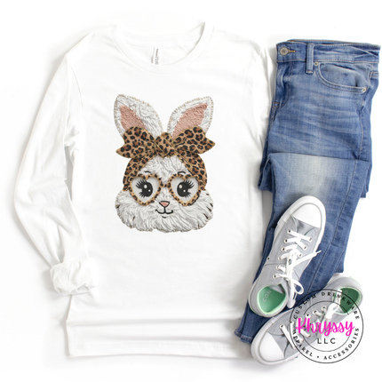 White sweatshirt with bunny design, blue jeans, and white sneakers on a white background.