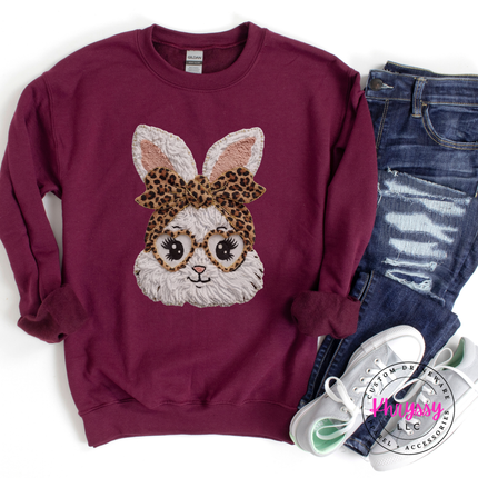 Maroon sweatshirt with a bunny design wearing glasses and a leopard print bow, paired with jeans and sneakers on a white background.
