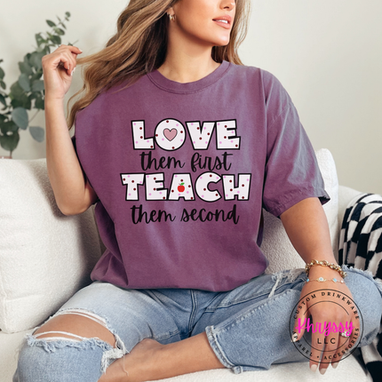 Love them first teach them second polka dot teacher statement on Berry Comfort Colors tee with heart and apple detail