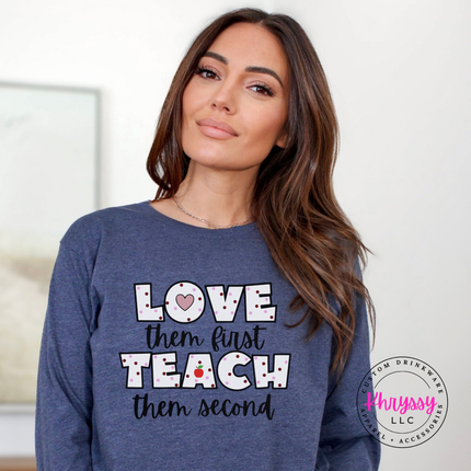 Love them first teach them second polka dot long sleeve on heather dark navy Bella Canvas with heart and apple detail
