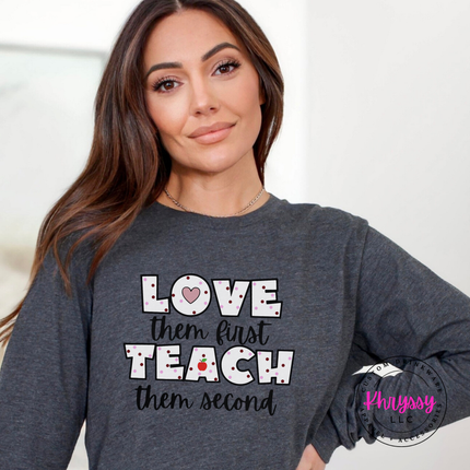 Warm love them first teach them second long sleeve on dark heather Bella Canvas with playful apple heart detail