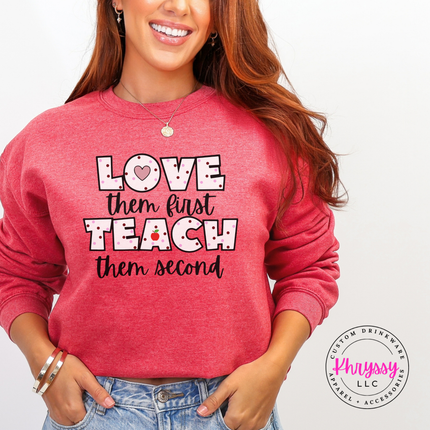 Love them first teach them second polka dot crewneck on heather sport scarlet Gildan sweatshirt with teacher heart and apple detail