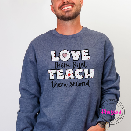 Warm cheerful teacher heart crewneck on heather sport dark navy Gildan with black polka dot lettering and red apple graphic