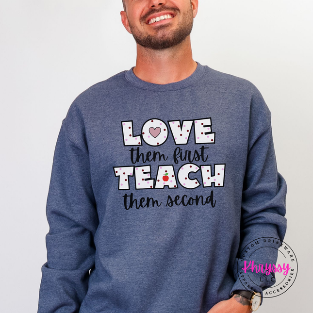 Warm cheerful teacher heart crewneck on heather sport dark navy Gildan with black polka dot lettering and red apple graphic