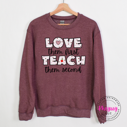 Clean Heather sport dark maroon Gildan crewneck featuring love them first teach them second black polka dot apple teacher statement