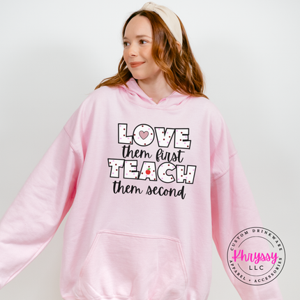 Warm Light Pink Gildan hoodie featuring love them first teach them second polka dot teacher heart apple statement