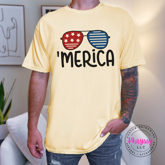 Butter garment-dyed tee with a retro patriotic sunglasses and Merica graphic.