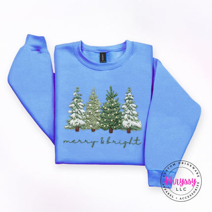 Close up of embroidery style trees on a Carolina Blue crewneck sweatshirt.
