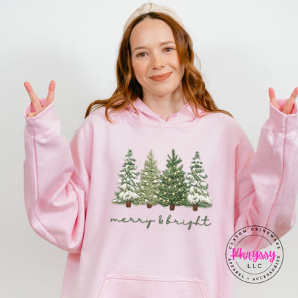Light Pink pullover hoodie showing four snowy evergreen trees above soft script lettering.