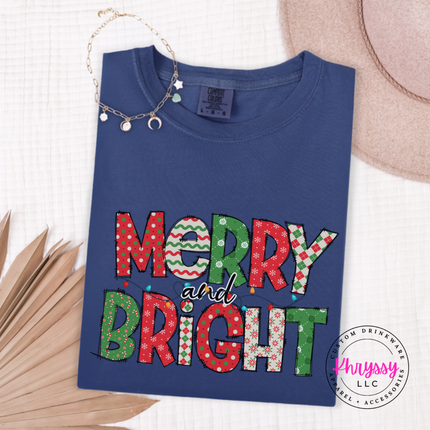 Close up of the Merry and Bright patterned art on a Navy tee.