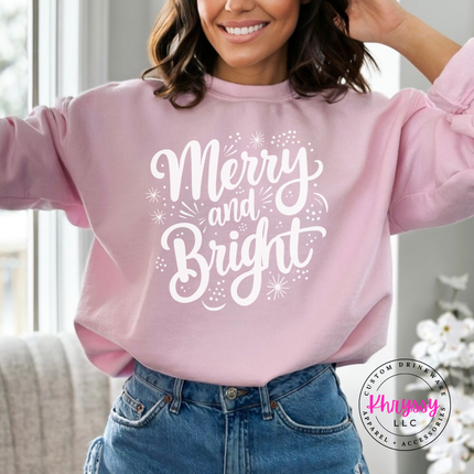 Light Pink crewneck sweatshirt featuring flowing Merry and Bright script lettering.
