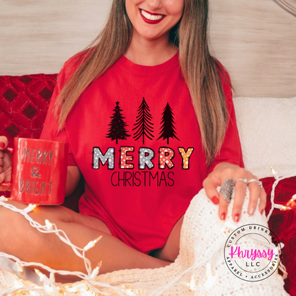 Red tee showing three pines over glittery Merry letters.
