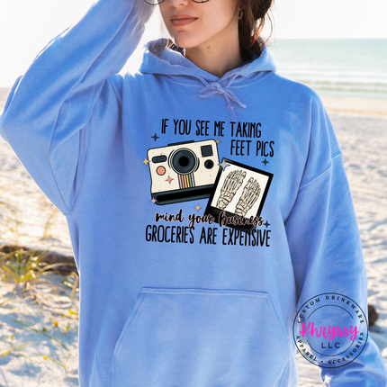 Person wearing a blue hoodie with a graphic design on a beach