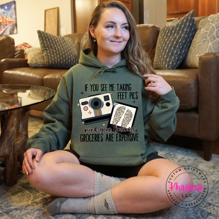 Person wearing a green hoodie with a graphic design sitting on the floor in a living room.