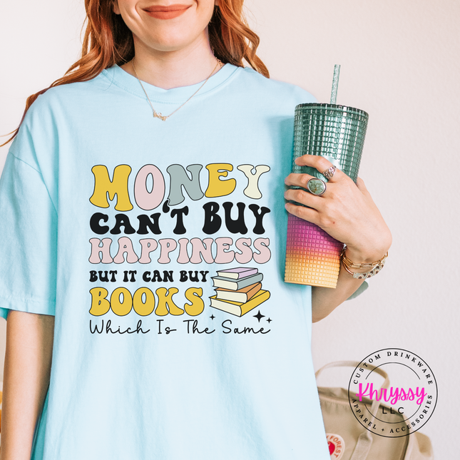 Person wearing a light blue t-shirt with a motivational quote, holding a colorful drink cup.