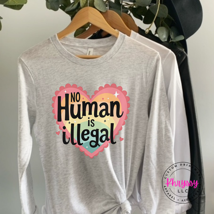 Gray long-sleeve shirt with 'No Human is Illegal' design on a hanger.