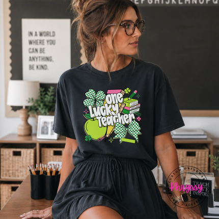 Black comfort colors tee with a colorful one lucky teacher shamrock print.