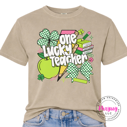 Khaki garment-dyed tee featuring checkered shamrocks and a leopard bolt.