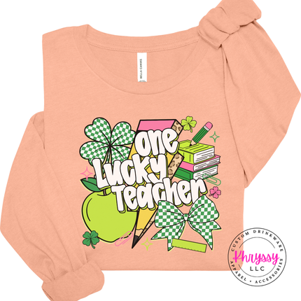 Peach long sleeve tee showing white lettering over a shamrock design.