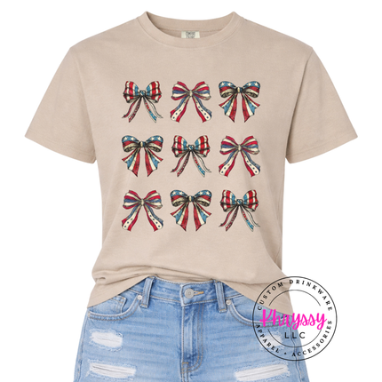 Sandstone garment-dyed tee with a grid of vintage American flag bows.Sandstone garment-dyed tee with a grid of vintage American flag bows.
