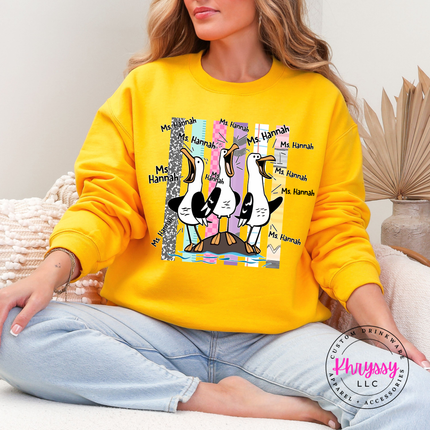 Gold colored crewneck sweatshirt with a personalized seagull teacher design and custom name.
