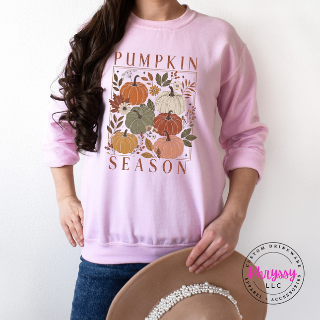 Light pink crewneck sweatshirt featuring a blush and rust pumpkin illustration.