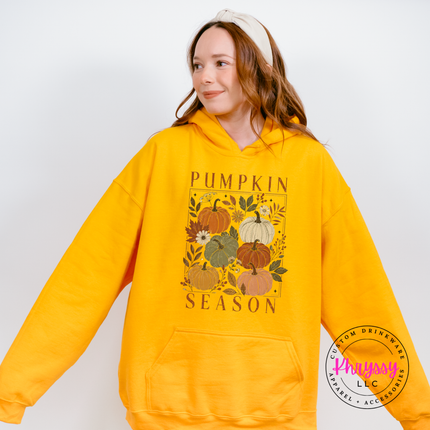 Gold pullover hoodie with a hand-illustrated pumpkin season floral graphic.