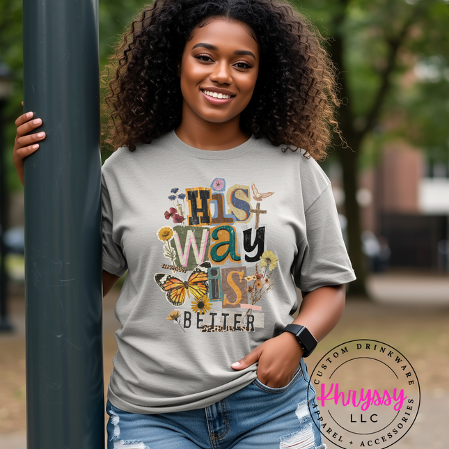 Woman wearing a gray t-shirt with a colorful design, standing outdoors.