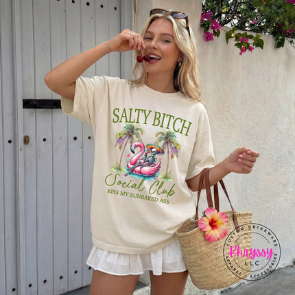 Ivory beach tee with a sassy flamingo float skeleton design.