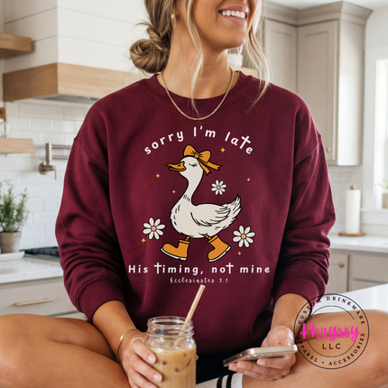 Maroon crewneck sweatshirt showing a white goose and daisies faith graphic.