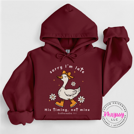Maroon pullover hoodie showing a white goose and daisies faith graphic.