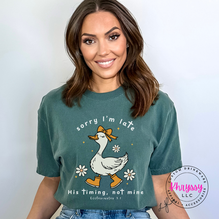 Blue Spruce garment-dyed tee with a white Sorry I'm Late goose faith graphic.