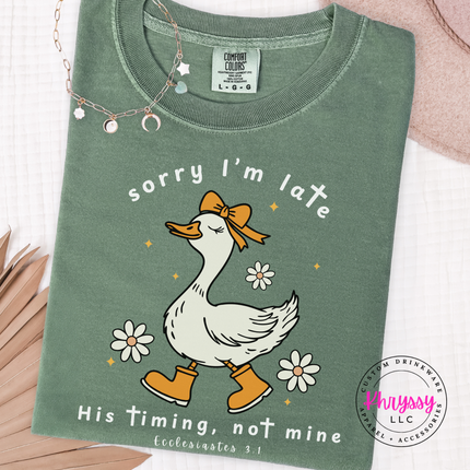 Moss garment-dyed tee showing a white goose and daisies faith graphic.