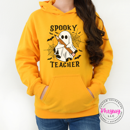 Gold hoodie featuring a ghost holding a pencil with bats and cobwebs.