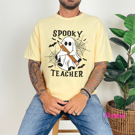 Butter tee featuring a ghost holding a pencil with bats and cobwebs.