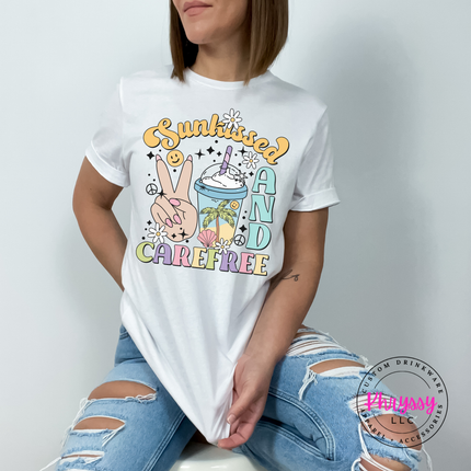 White garment-dyed tee displaying a retro pastel Sunkissed and Carefree design.