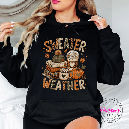Black hoodie featuring a sweater weather design with books, coffee and pumpkins