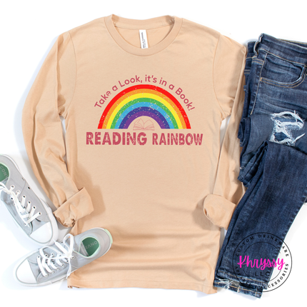 Sand dune tee showing a colorful rainbow and open book print.